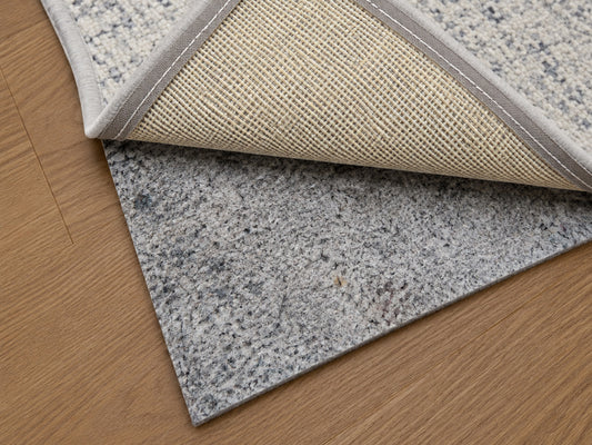 Designer cushioned non-slip rug pad under an area rug on a hardwood floor